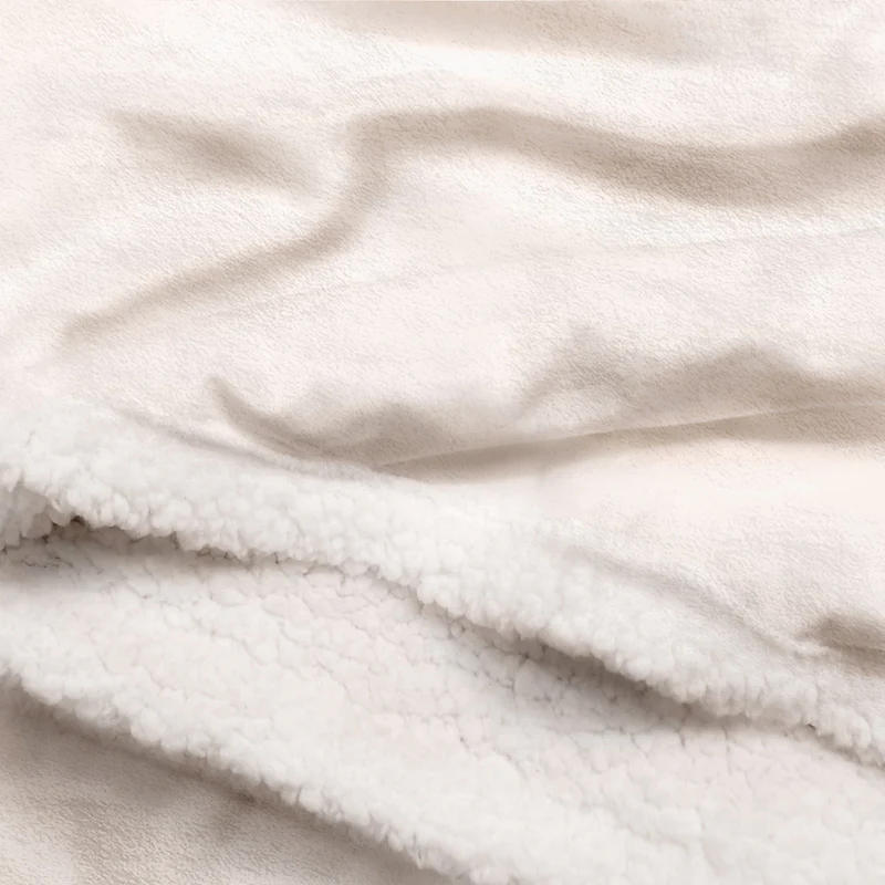 Close-up of a soft, cream-colored custom fleece blanket texture, highlighting the sherpa fleece material.