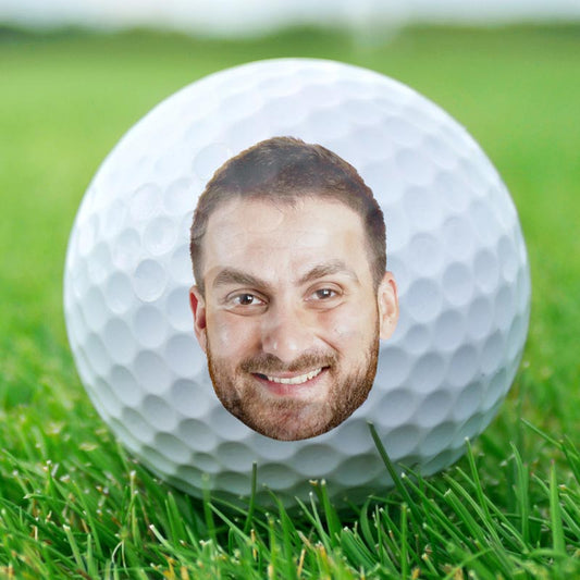 Custom golf ball with a personalized face on green grass, "If found return to this guy" gift for golf lover.