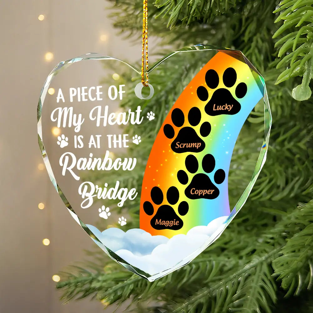 Personalized pet memorial ornament with rainbow and paw prints. Glass heart-shaped Christmas tree decoration.